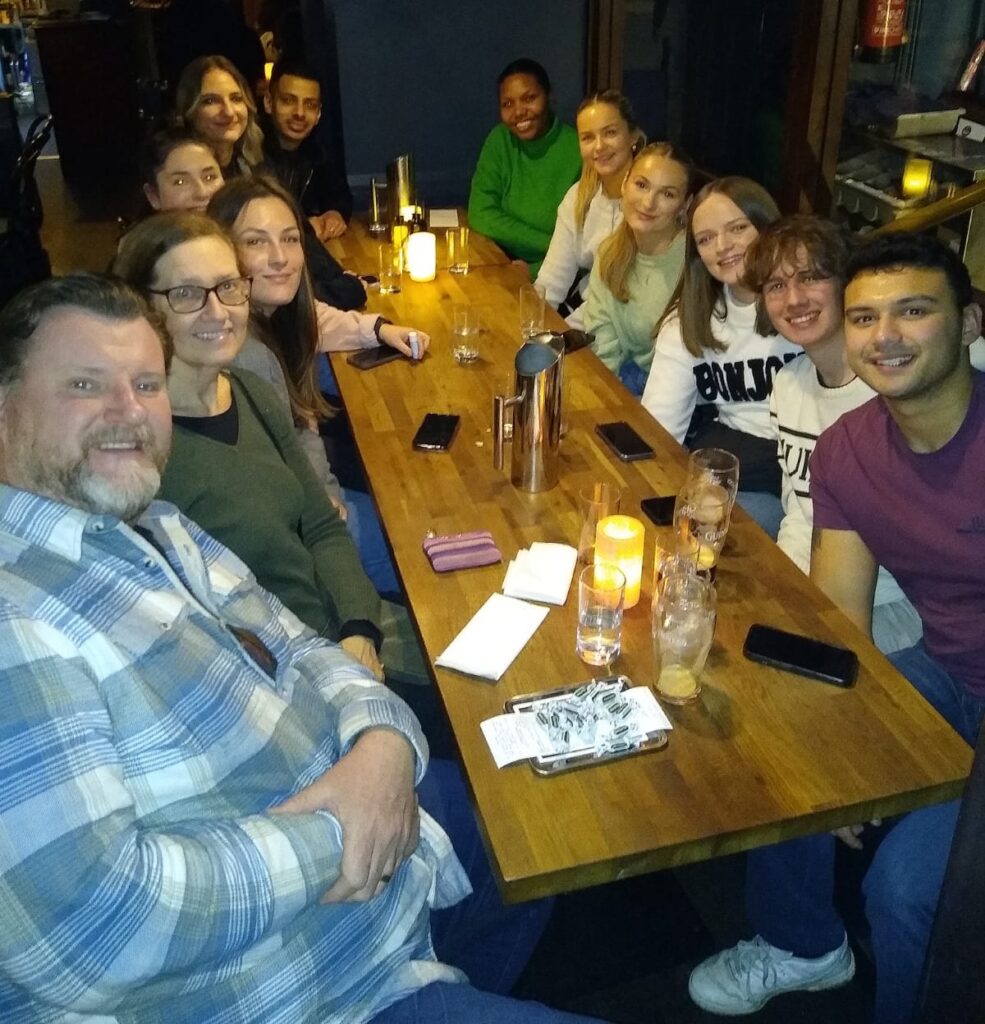 Group of staff and students sitting round table in a restaurant